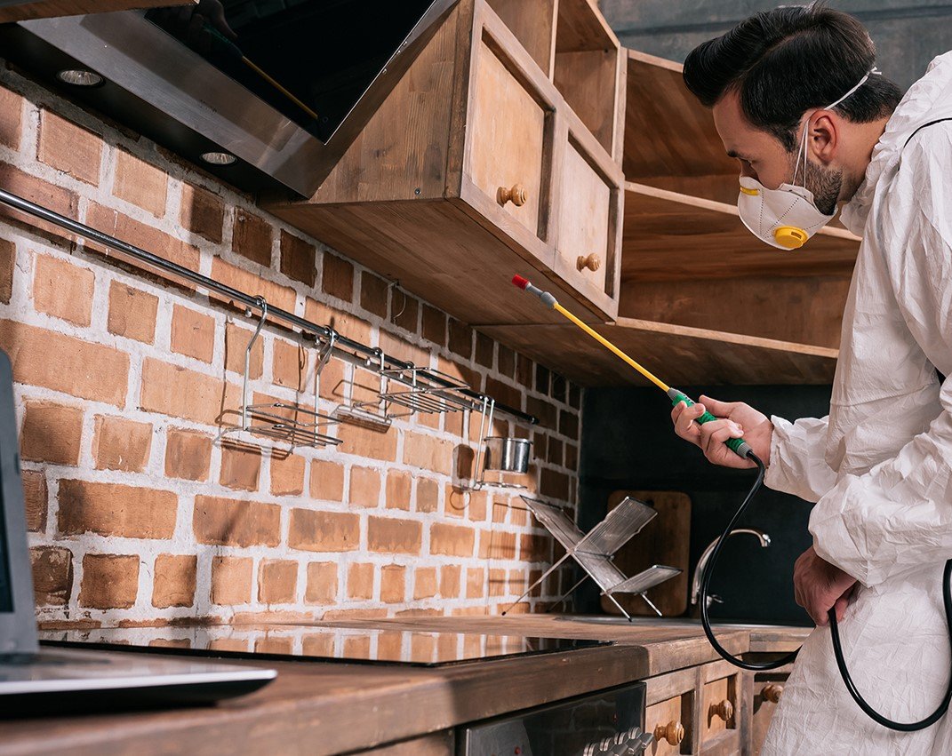 Técnico de IAMIP aplicando control de plagas en una cocina